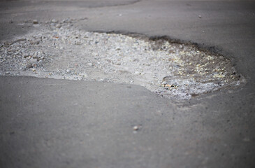 Broken asphalt and cracks on the road surface