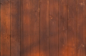 Obraz premium Brown wooden vertical plank fence with sun glare.
