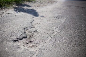 Broken asphalt and cracks on the road surface