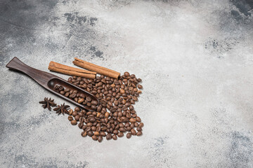 Coffee beans with a wooden spoon and cinnamon sticks