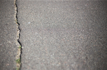 Broken asphalt and cracks on the road surface