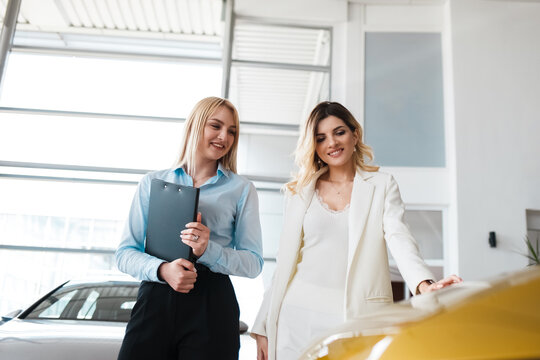 Dealership consultant shows cars to a client