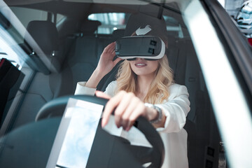 Pretty woman sitting in a car in 3D glasses of virtual reality