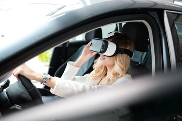 Pretty woman sitting in a car in 3D glasses of virtual reality