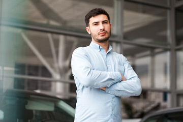 Portrait of a stylish man at a car dealership