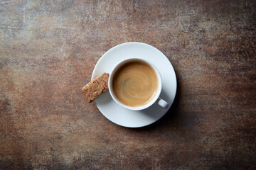 Cup of coffee with cantuccini (Italian biscuit) on rustic stone background. Top view. Copy space.
