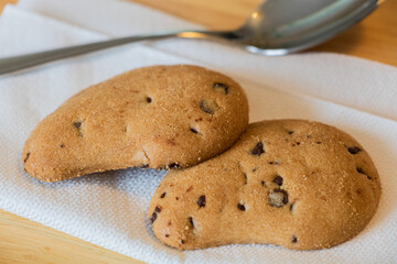 Couple Chocolate Cookies on Paper Napkin whit Silver Spoon on Background