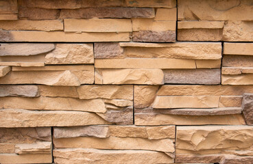 Stone facing of facades and walls.The wall is made of decorative facing stone, such as Sandstone or slate. The texture of the stone