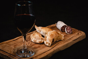 typical argentinian food. empanadas, glass of wine and cold cuts