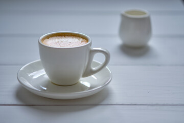 Morning espresso coffee on a white wooden table.