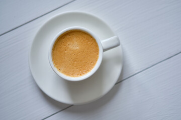 Morning espresso coffee on a white wooden table.