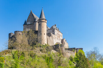 Fototapeta na wymiar Vianden castle on the hill view with blue sky background and green trees. Luxembourg