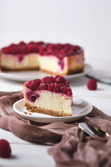 Morning breakfast with raspberry cheesecake. Slice of dessert on a plate and coffee on a white wooden table.