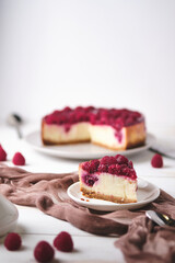 Morning breakfast with raspberry cheesecake. Slice of dessert on a plate and coffee on a white wooden table.