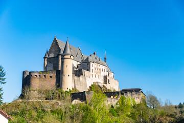 Fototapeta na wymiar Vianden castle on the hill view with blue sky background and green trees. Luxembourg