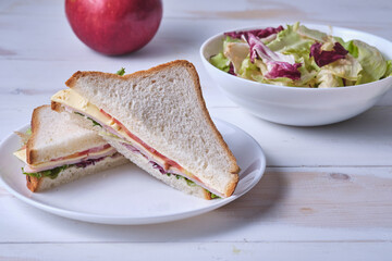 School breakfast. Salad, sandwich and apple.