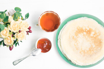 Pancakes, a bouquet with roses, a beautiful vintage breakfast. Sea buckthorn jam. Romantic breakfast for Valentine's Day on February 14 on a white background. Greeting card template. Mother's day card