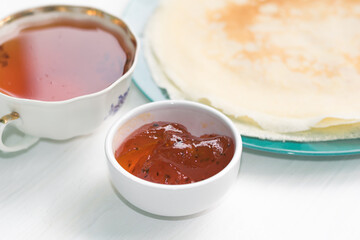 Pancakes, a bouquet with roses, a beautiful vintage breakfast. Sea buckthorn jam. Romantic breakfast for Valentine's Day on February 14 on a white background. Greeting card template. Mother's day card