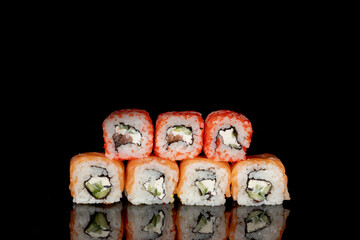 Philadelphia roll with salmon, cheese and cucumber on a black background with reflection. Sushi Philadelphia