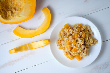 Risotto with pumpkin close-up. Italian dish on a white table.
