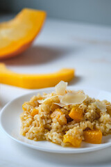 Risotto with pumpkin close-up. Italian dish on a white table.