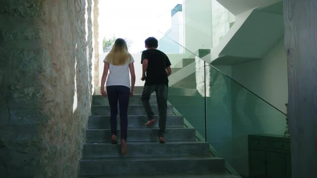 WS TU Boy (14-15) and girl (12-13) walking up stairs 