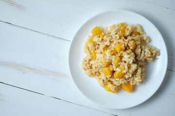 Risotto with pumpkin close-up. Italian dish on a white table.