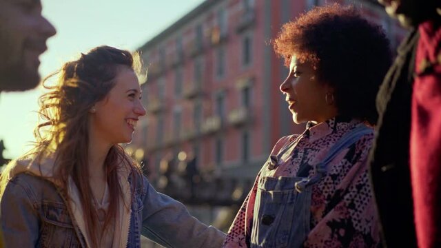 CU SELECTIVE FOCUS Group of friends talking and laughing outdoors / Milan, Italy