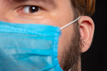 soft focus close face portrait male person with ear and respiration medicine mask