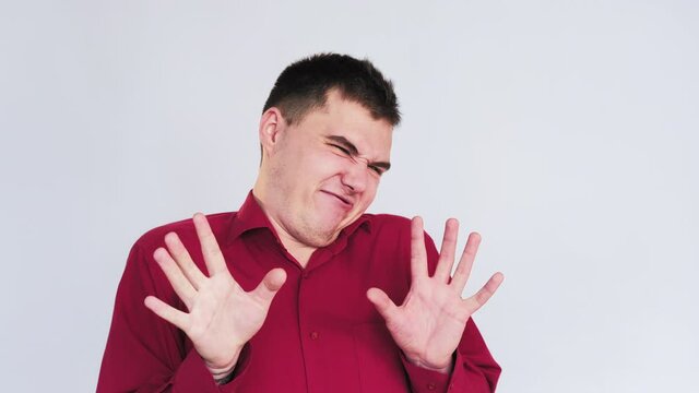 Skeptic man portrait. So-so gesture. Funny guy showing dislike no signal isolated on neutral background.