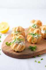 Profiteroles with soft cheese, red fish and herbs. A gourmet meal for the holiday table.