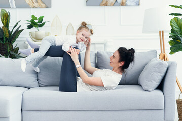 mom and her daughter lying on the couch in the living room.