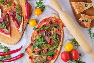 Homemade Italian pizzas: spicy with chili and smoked sausage; piquant with olives and two kinds of sausages; calzone with mazarella, tomatoes, tomato sauce, sausage, olives and arugula.
