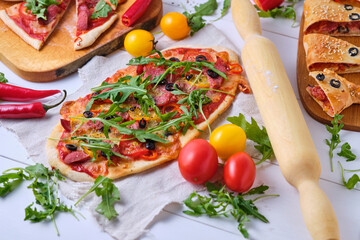Homemade Italian pizzas: spicy with chili and smoked sausage; piquant with olives and two kinds of sausages; calzone with mazarella, tomatoes, tomato sauce, sausage, olives and arugula.