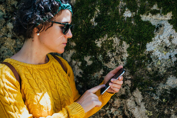 mujer en el monte con telefono y auriculares