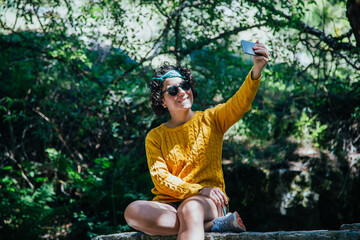 mujer en el monte con telefono y auriculares