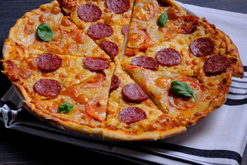 Pepperoni pizza and margarita pizza together. Joint pizza on a dark wooden background. Homemade pizza.