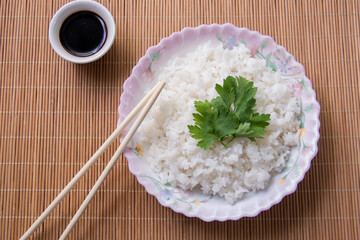 boiled rice with soy sauce close-up on a light background