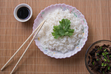boiled rice with soy sauce close-up on a light background