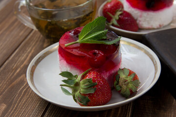 dessert with strawberries close-up on a decorative background. Strawberry jelly. 
Delicate Strawberry Cheesecake On A White Plate