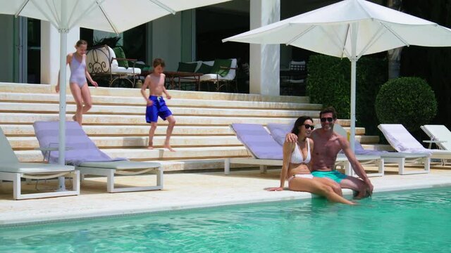 WS Children (12-13, 14-15) joining parents sitting on poolside / Majorca, Spain