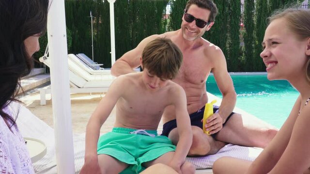 MS Family with children (12-13, 14-15) relaxing on lounge chairs 