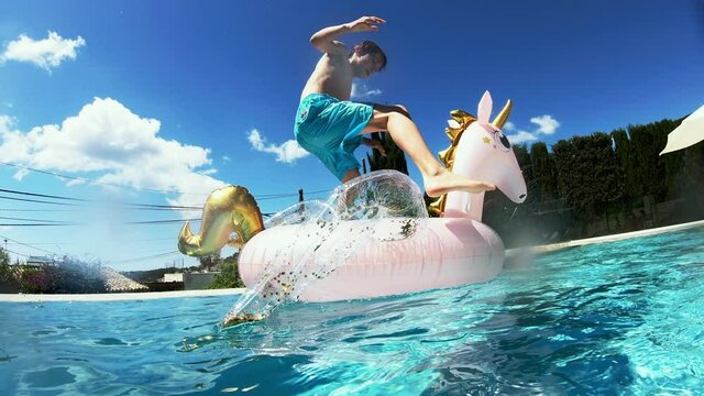 MS Boy (14-15) jumping into pool on unicorn pool raft and falling 