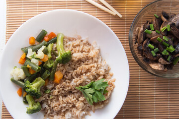 Rice with soy sauce and boiled vegetables close-up on a decorative background. Rice Dish. Fried mushrooms. Healthy eating Vegetarian food. Vegetarian dish