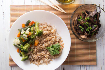 Rice with soy sauce and boiled vegetables close-up on a decorative background. Rice Dish. Fried mushrooms. Healthy eating Vegetarian food. Vegetarian dish