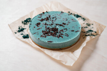Obraz na płótnie Canvas Green vegan cake with spirulina. Homemade baking. Top view. Delicious round tart with spirulina on the wooden table.