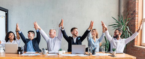 Business Colleagues Giving High-Five Celebrating Success Sitting In Office, Panorama