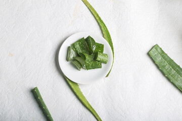 Freshly sliced aloe vera on a white plate surrounded by aloe leaves, top view with space for text. Natural treatment for all types of skincare in Indian Ayurveda. Food Concept Shot.