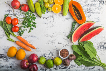 Various Fruits and Vegetables (Mango, Apple, Orange, Tangerine, Tomato, Carrot, Water Melon, Spinach, Pomegranate, Papaya) on a plain background, top view, creative flat layout. Healthy Eating Concept
