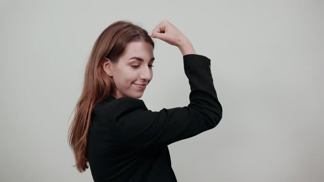 Feels proud have strength, shows great power, raises arms to show muscles confident in victory, looks strong and independent, flexing arm, facial expressions, feelings, attitude, life perception
